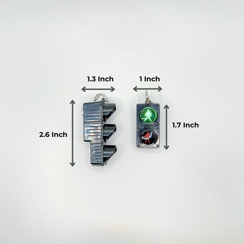 May include: Two traffic light keychains, one red, yellow, and green, and the other green and red. The red, yellow, and green traffic light keychain is 2.6 inches tall and 1.3 inches wide. The green and red traffic light keychain is 1.7 inches tall and 1 inch wide.