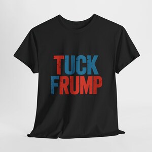 May include: Black t-shirt with the words "TUCK FRUMP" printed in red and blue. The text has a distressed, vintage look. The shirt is made of a soft material and has short sleeves.