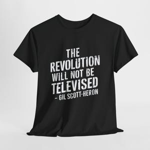 May include: A black short-sleeved t-shirt featuring white distressed-style text that reads THE REVOLUTION WILL NOT BE TELEVISED - GIL SCOTT-HERON centred on the chest. The garment has a crew neckline and a standard fit with short sleeves.