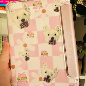 Pode incluir: Uma capa de telefone quadriculada rosa e branca com um padrão de rosto de cachorro branco e o texto "Download digital!" impresso no topo.