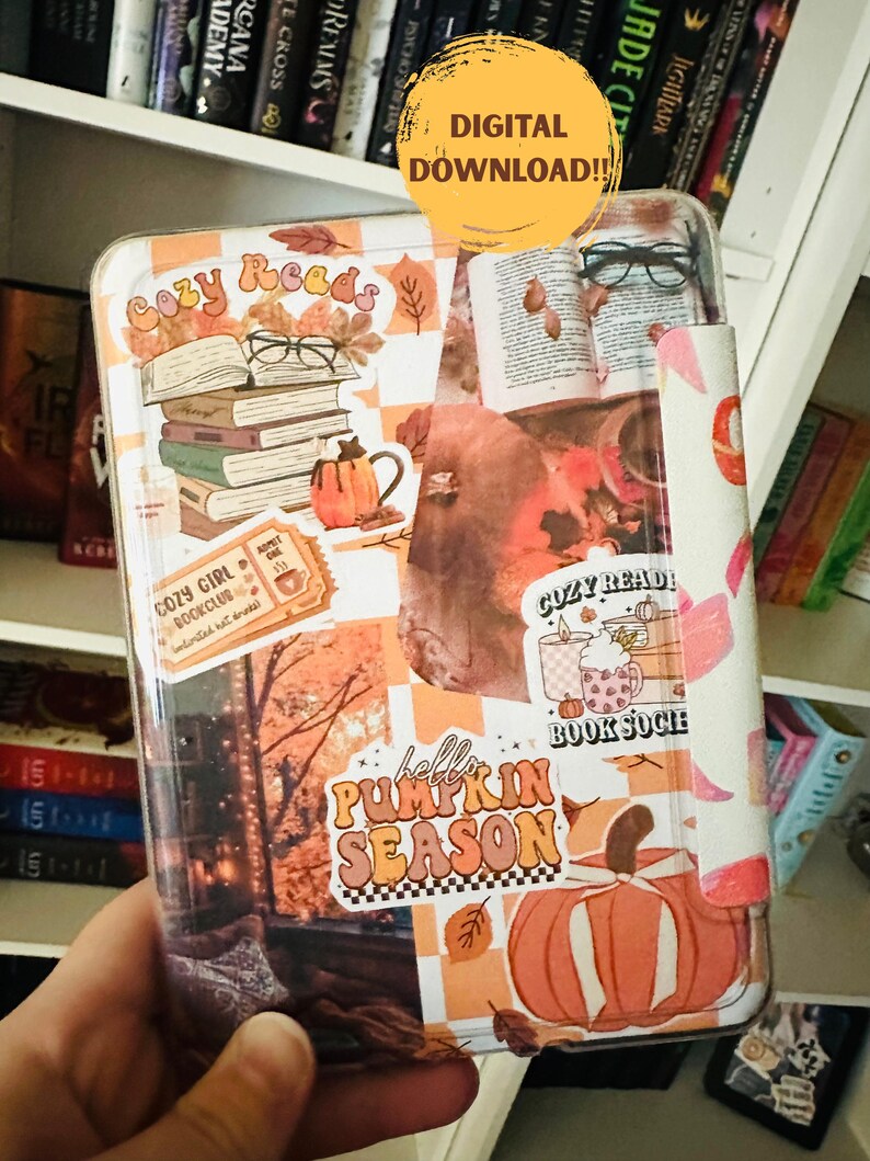 May include: A clear case for an e-reader, decorated with autumn-themed stickers. The design includes stacks of books, pumpkins, and the text "hello PUMPKIN SEASON". The case is held in a person's hand, with a bookshelf in the background.