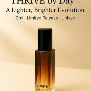 May include: A perfume bottle with a black cap and a rectangular, amber-colored glass body. The bottle is labeled "THRIVE" and the text "Introducing THRIVE by Day - A Lighter, Brighter Evolution" is above it. The bottle contains 10ml and is a limited release.