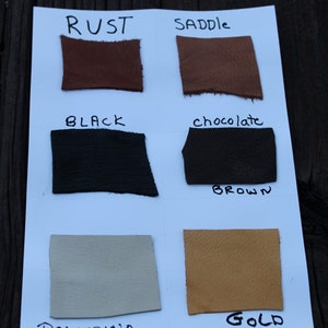 K&ouml;nnte beinhalten: Lederproben in verschiedenen Farben, darunter Rost, Sattel, Schwarz, Schokoladenbraun, Palomino und Gold. Die Proben sind mit ihren jeweiligen Farben und dem Text "Deer Hides" beschriftet.