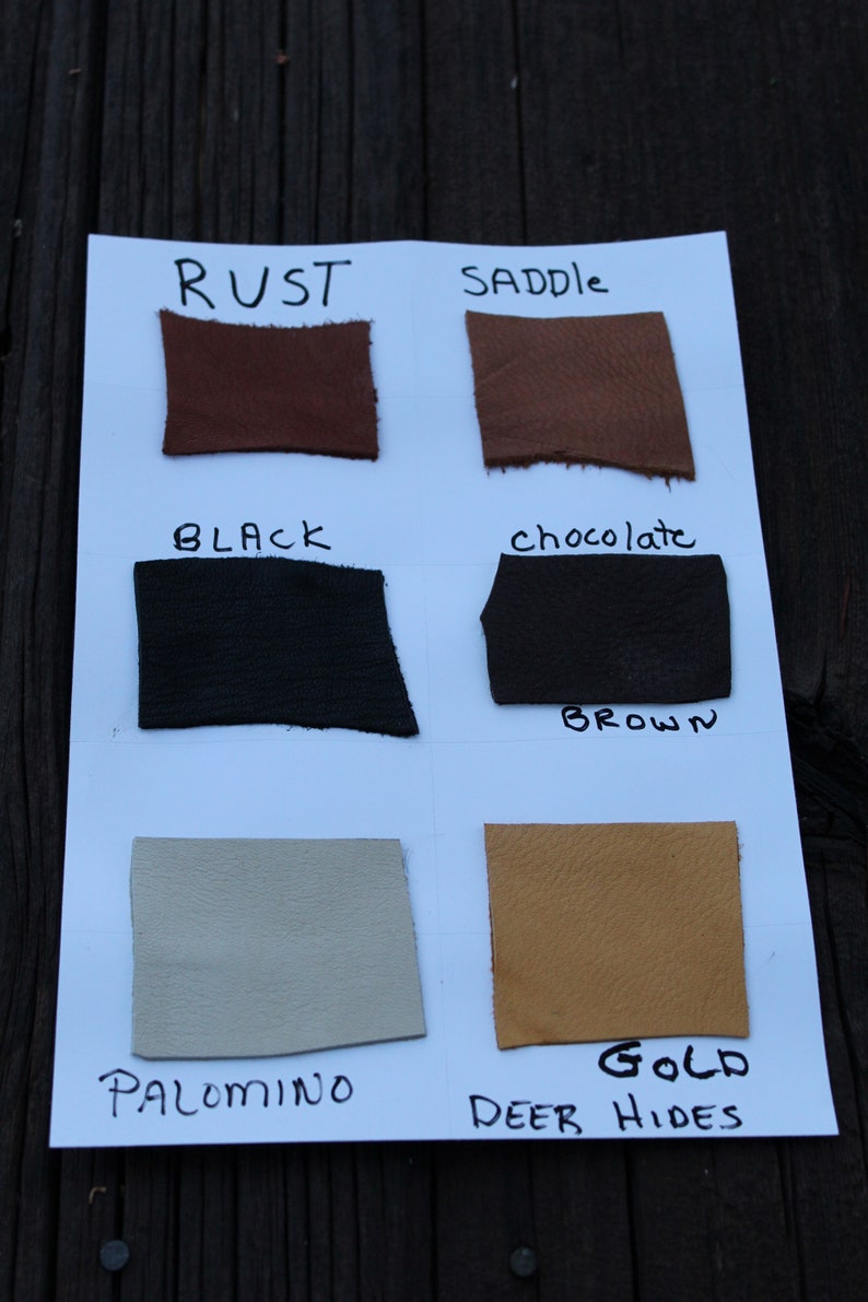K&ouml;nnte beinhalten: Lederproben in verschiedenen Farben, darunter Rost, Sattel, Schwarz, Schokoladenbraun, Palomino und Gold. Die Proben sind mit ihren jeweiligen Farben und dem Text "Deer Hides" beschriftet.