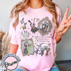 May include: A light pink t-shirt featuring a graphic print of characters from The Nightmare Before Christmas. The design includes Jack Skellington, Sally, Oogie Boogie, and Zero, with the text The Nightmare Before Christmas The Pumpkin Queen & The Pumpkin King.