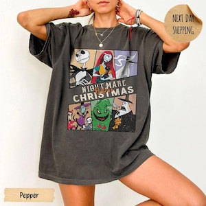May include: A charcoal gray short-sleeve t-shirt featuring a multi-panel graphic print of characters from The Nightmare Before Christmas. The design includes Jack Skellington, Sally, Zero, Oogie Boogie, and the Mayor with the text Nightmare Before Christmas.