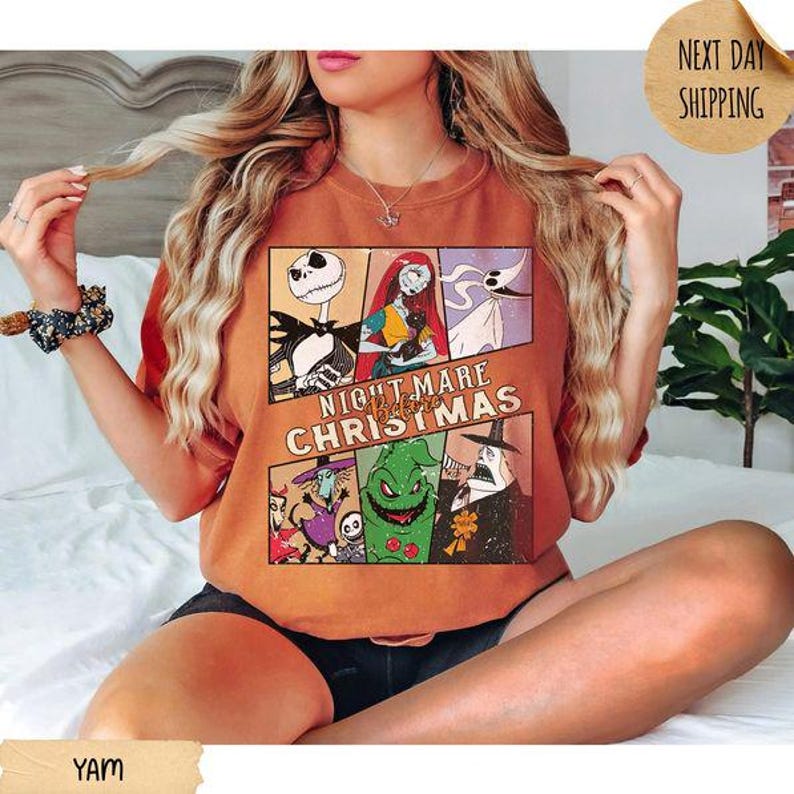 May include: A burnt orange short-sleeve t-shirt featuring a multi-panel graphic print of characters from The Nightmare Before Christmas, including Jack Skellington, Sally, Zero, and Oogie Boogie, with the movie title text centered in the design.