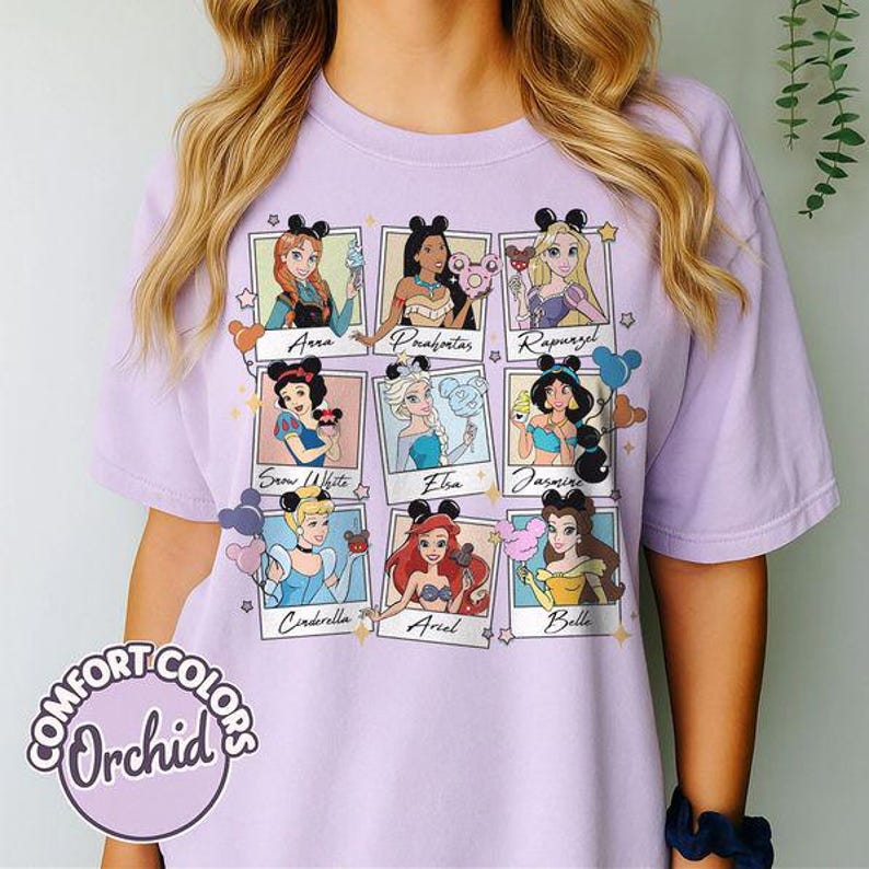 May include: A light purple Comfort Colors t-shirt featuring a grid of nine Disney princesses, each in a framed photo with their names. The princesses are depicted with their iconic looks and accessories. The shirt has the word "Orchid" in a circle.