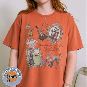 May include: An orange short-sleeve t-shirt featuring a graphic print of characters from The Nightmare Before Christmas. The design includes Jack Skellington, Sally, Oogie Boogie, and other figures in frames with the text The Nightmare Before Christmas.