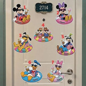 May include: Seven Disney character stickers featuring Mickey, Minnie, Pluto, Chip, Dale, Goofy, Donald, and Daisy wearing sunglasses and patriotic shirts while in pool floats. Each sticker includes a space labeled Name and a number from 1 to 7.