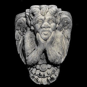 May include: A gray stone sculpture of a winged gargoyle with a mischievous grin, holding its hands to its chin. The gargoyle is carved with intricate details and has a whimsical expression.