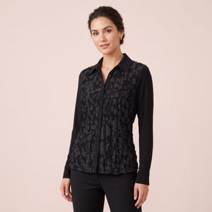 May include: A black long-sleeve button-down shirt featuring a textured floral appliqué pattern on the front panel, a classic collar, and solid black sleeves. The garment is paired with black trousers, creating a monochromatic ensemble.