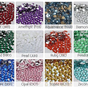 Pode incluir: Uma cole&ccedil;&atilde;o de doze grupos de pequenos strass redondos e facetados em v&aacute;rias cores, cada um rotulado com o nome de uma pedra de nascimento e m&ecirc;s: Garnet (JAN), Amethyst (FEB), Aquamarine (MAR), Diamond (APR), Emerald (MAY), Pearl (JUN), Ruby (JUL), Peridot (AUG), Sapphire (SEP), Opal (OCT), Topaz (NOV) e Zircon (DEC).