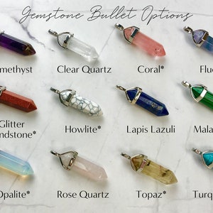 Pu&ograve; includere: Una collezione di pendenti a proiettile di pietre preziose in vari colori, tra cui ametista, quarzo trasparente, corallo, fluorite, arenaria glitterata, howlite, lapislazzuli, malachite, opale, quarzo rosa, topazio e turchese. Ogni pendente ha un cappuccio in metallo color argento.
