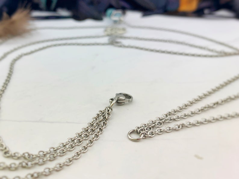 Pu&ograve; includere: Collana a catena color argento con pi&ugrave; fili. La collana presenta un design delicato con piccole maglie a catena. La chiusura &egrave; visibile e la collana sembra essere in metallo.