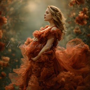 Puede incluir: Una mujer con un vestido fluido de color óxido está en un jardín. El vestido presenta detalles con volantes y una larga cola. La imagen tiene una estética suave y romántica, con el texto "In The Lens by Kuminiski" en la esquina inferior izquierda.