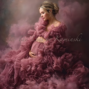 May include: A woman in a flowing, ruffled mauve gown, cradling her pregnant belly. The dress has a layered, textured design. The background is a soft, smoky blend of mauve and brown tones, creating a dreamy atmosphere. The image has the text "In The Lens Kaminski".