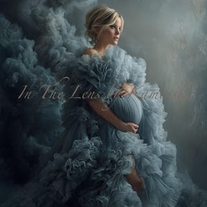 May include: A woman in a flowing, layered, blue-grey gown, with the text "In The Lens by Kamarshk". The dress has a ruffled texture, creating a cloud-like effect. The woman is holding her pregnant belly.