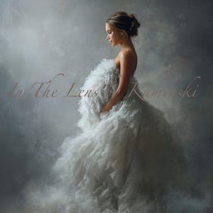 Può includere: Una donna in un abito bianco a strati, con il testo "In The Lens Kamerski" in un carattere morbido ed elegante. L'abito ha un design voluminoso e arruffato. Lo sfondo è grigio fumoso.