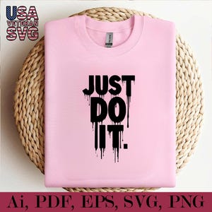 K&ouml;nnte beinhalten: Rosa T-Shirt mit schwarzem Text, der "JUST DO IT." lautet. Der Text tropft und verleiht ihm einen stilisierten Look.