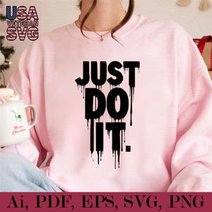 K&ouml;nnte beinhalten: Ein rosa Sweatshirt mit dem Text "JUST DO IT." in schwarzen, tropfenden Buchstaben.