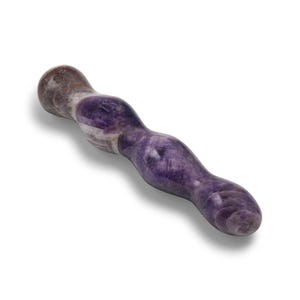 May include: A purple and white amethyst wand with a smooth, curved design. The wand is a natural stone with varying shades of purple and white, and is designed with a rounded tip and a curved shape.