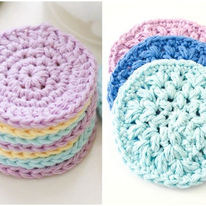 May include: A set of four crocheted coasters in pastel colors. The coasters are made with a circular design and have a soft, textured surface.
