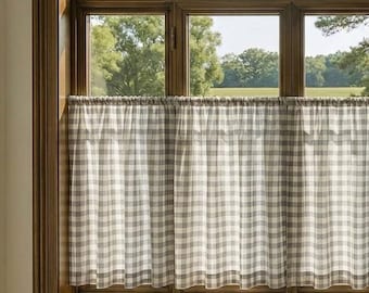 May include: A cafe curtain featuring a light gray and white checkered pattern, hung on a rod across the lower half of a large arched window with a dark wood frame. The fabric is semi-sheer, allowing natural light to filter through the window.