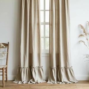 May include: Beige linen curtains with a ruffled hem, hanging from a dark brown rod. The curtains frame a white window, and a wooden chair with a vase of flowers sits to the left. A woven basket with dried plants is on the right.