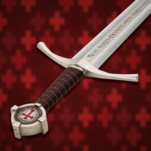 May include: A medieval-style sword with a silver blade and guard, featuring a brown leather-wrapped handle. The pommel displays a red cross emblem. The blade is inscribed with the words "NON NOBIS DOMINE NON NOBIS SED".