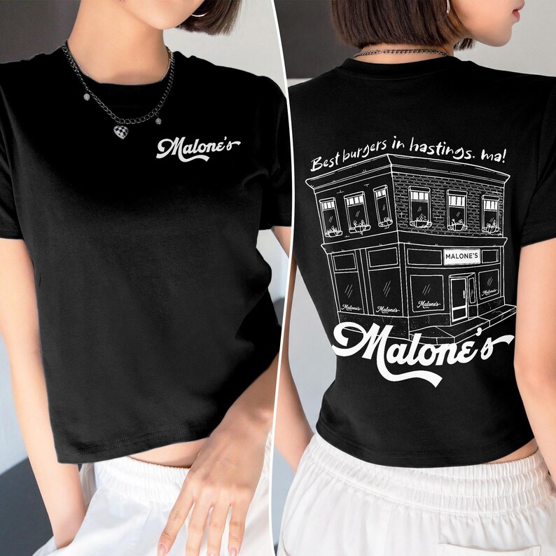May include: A black short-sleeved t-shirt featuring the white text Malone's on the front chest. The back displays a white line-art illustration of a building with the text Best burgers in hastings. ma! and the word Malone's in large script.