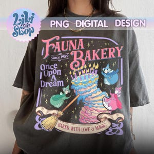 May include: Dark gray t-shirt featuring a whimsical design for "Fauna Bakery" with a cake, fairies, and the text "Baked with Love & Magic." The design includes the text "Once Upon A Dream" and "Since 1959."