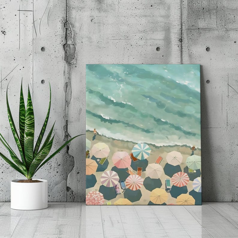 May include: A canvas print depicting a beach scene from a bird's-eye view. The artwork features a turquoise ocean meeting a sandy shore dotted with colorful beach umbrellas. The umbrellas are in shades of pink, yellow, and blue, creating a vibrant summer scene.
