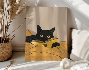 Puede incluir: Impresión en lienzo de un gato negro leyendo un libro amarillo, acostado sobre una manta amarilla. El gato tiene ojos amarillos y el fondo es neutro. La obra de arte se exhibe en interiores, apoyada contra una pared.