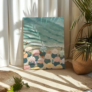 May include: An artistic canvas print depicting a beach scene from a high angle. The artwork features colorful beach umbrellas, people, and the ocean. The color palette includes blues, greens, pinks, and yellows, creating a summery vibe. The canvas is displayed on a neutral-toned rug.