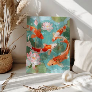 Könnte beinhalten: Leinwanddruck mit Koi-Karpfen und Lotusblüten in einem Teich. Die Fische sind orange und weiß, vor einem türkisfarbenen Hintergrund mit grünen Seerosenblättern und rosa Lotusblüten. Das Kunstwerk wird in Innenräumen ausgestellt.