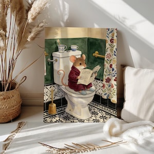 May include: A rectangular wall art print featuring a brown mouse wearing a maroon robe and blue slippers, sitting on a white toilet while reading a newspaper. The bathroom scene includes a green wall, a floral shower curtain, and a toothbrush in a cup.