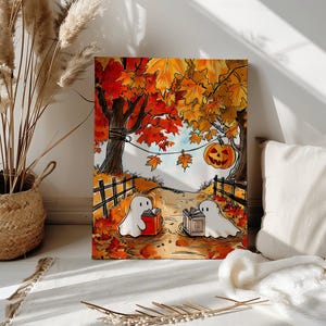 Puede incluir: Impresión en lienzo con temática de Halloween. Dos fantasmas leyendo libros en un camino bordeado por una valla de madera. El fondo muestra árboles con hojas naranjas y amarillas, una calabaza tallada y hojas cayendo.