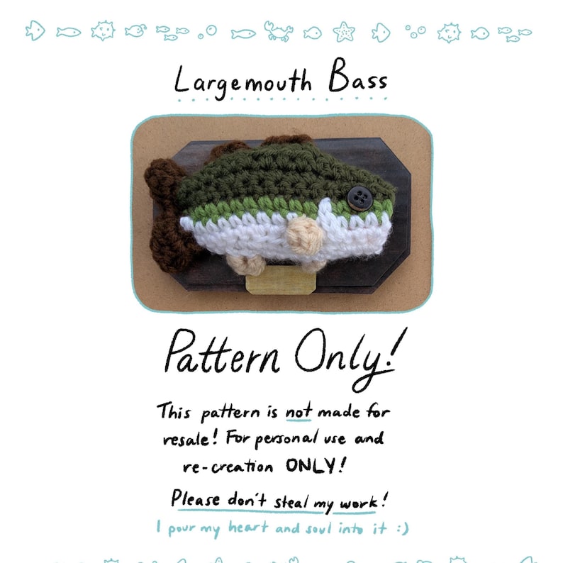 Op de afbeelding: Een gehaakte largemouth bass gemonteerd op een houten plaat. De vis is groen, wit en bruin, met een knoop als oog. De tekst "Largemouth Bass" en "Pattern Only!" worden weergegeven.