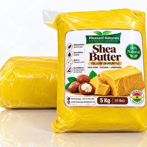 Può includere: Due sacchetti di plastica trasparente contenenti 5 kg di burro di karité giallo etichettati Pleazant Naturals. L'etichetta riporta scritte come Shea Butter, Yellow (Buruntu), 100% Pure, Natural, Unrefined e un badge circolare 100% Natural.