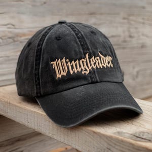 May include: A black baseball cap with a gold embroidered logo that says "Wingleader".