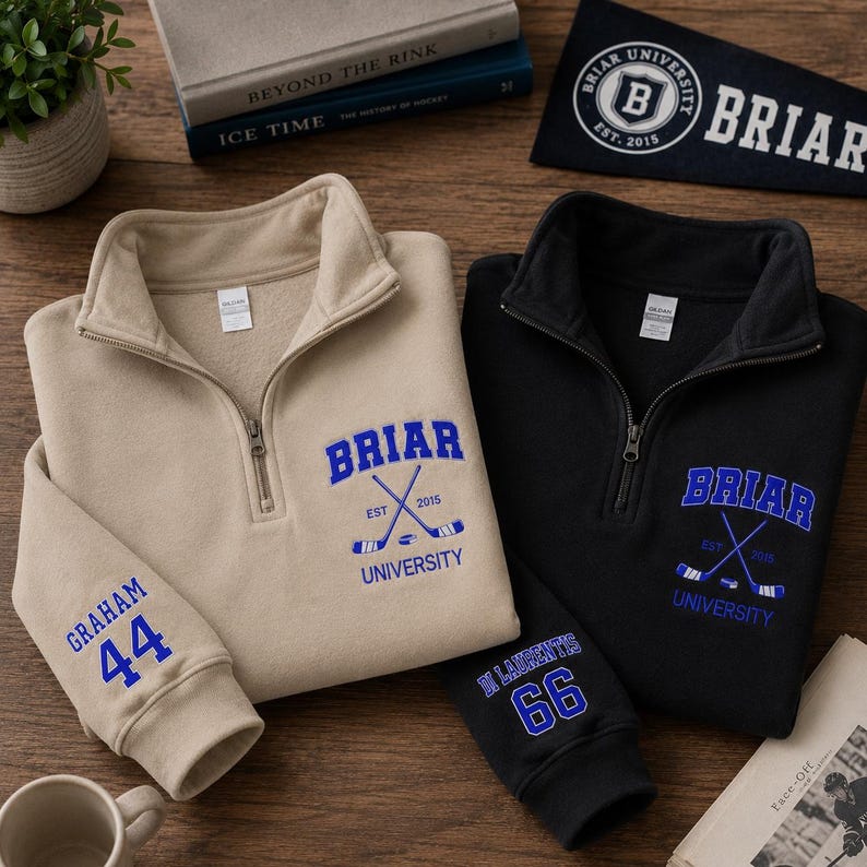 May include: Two quarter-zip sweatshirts, one tan and one black, with the word "Briar" in blue, crossed hockey sticks, and "University" printed below. The tan sweatshirt has "Graham 44" on the sleeve, and the black one has "Di Laurentis 66".