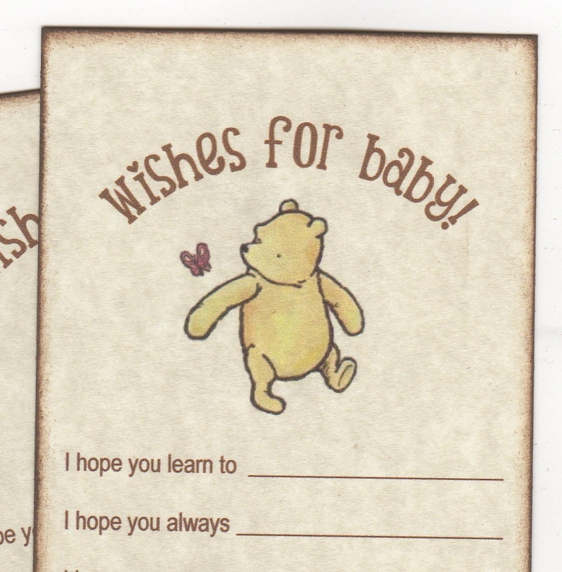 May include: A Winnie the Pooh themed baby shower card with a brown background and a Winnie the Pooh illustration. The card has the text "wishes for baby!" and two blank lines for writing wishes. The text "I hope you learn to" and "I hope you always" are printed on the card.