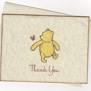 May include: A thank you card featuring a cartoon illustration of Winnie the Pooh walking with a butterfly. The text "Thank You" is written in brown cursive.