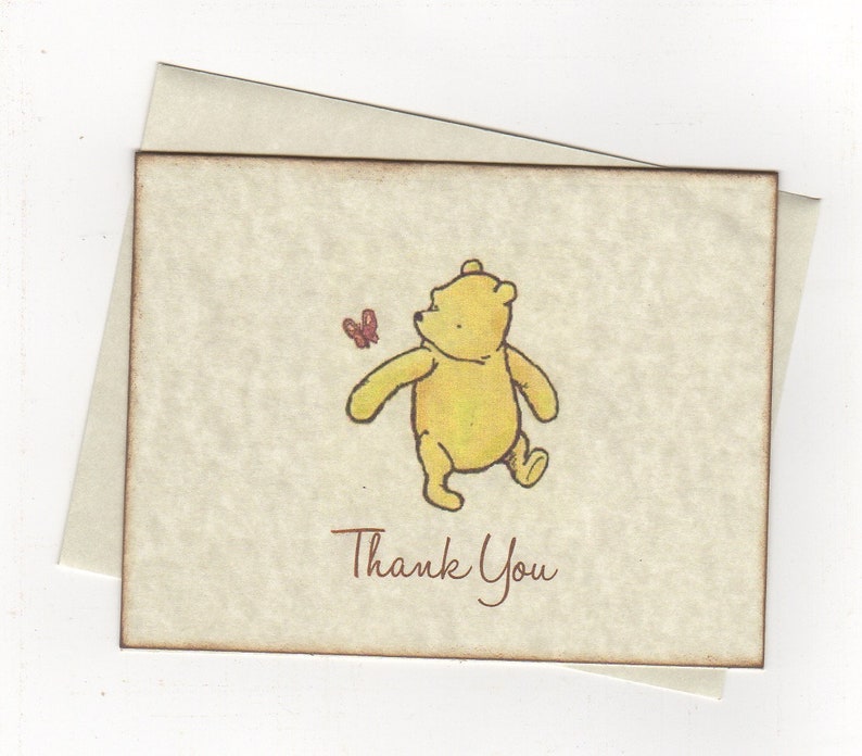 May include: A thank you card featuring a cartoon illustration of Winnie the Pooh walking with a butterfly. The card has a brown border and the text "Thank You" is printed in brown.