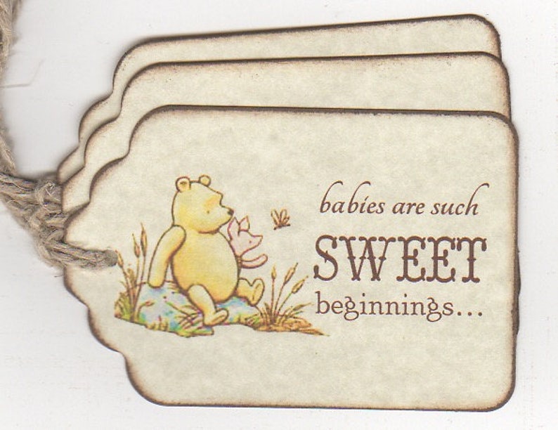 May include: Three beige paper tags with a brown border and scalloped edges. The tag features a Winnie the Pooh illustration with Piglet. The text on the tag reads "babies are such SWEET beginnings..."