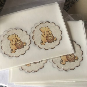 May include: Four white sheets of paper with a Winnie the Pooh design printed on each. The design features Winnie the Pooh holding a pot of honey that says "Hunny" on it.