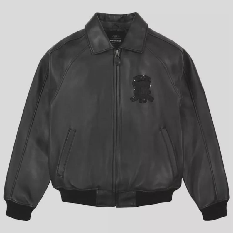 K&ouml;nnte beinhalten: Schwarze Lederjacke mit Rei&szlig;verschluss, Kragen und Aufn&auml;her auf der Brust. Die Jacke hat zwei Vordertaschen sowie gerippte B&uuml;ndchen und Saum. Der Markenname "AVIREX" ist am Kragen sichtbar.