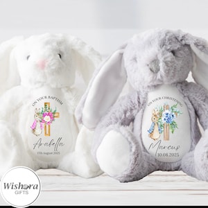 Peut inclure: Deux lapins en peluche, un blanc et un gris, avec des motifs personnalisés pour baptême et baptême. Le lapin blanc a un nez rose et un motif de croix avec le nom Arabella et la date du 17 août 2025. Le lapin gris a un motif de croix avec le nom Marcus et la date du 10 août 2025.
