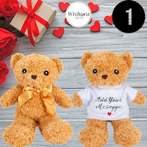 May include: Two brown teddy bears. One has a gold bow, the other a white t-shirt with "Add Your Message" and a heart. The background includes a gift box, red roses, and hearts. Ideal for a romantic gift.